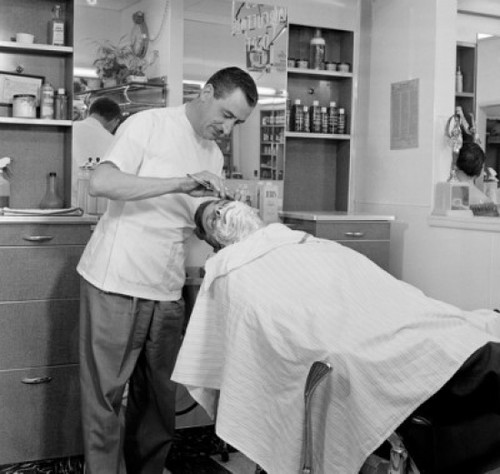 Barber shaving a mid adult man in a hair salon Poster Print - Item # VARSAL2557862