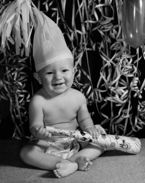Portrait of a baby boy holding a noisemaker and smiling Poster Print - Item # VARSAL255647