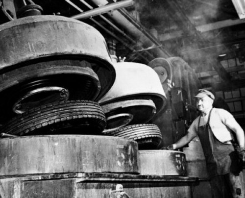 Low angle view of a male worker working in a tire factory Poster Print