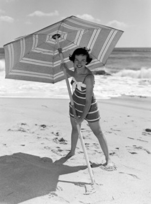 Young woman holding sun umbrella on beach Poster Print - Item # VARSAL255416424