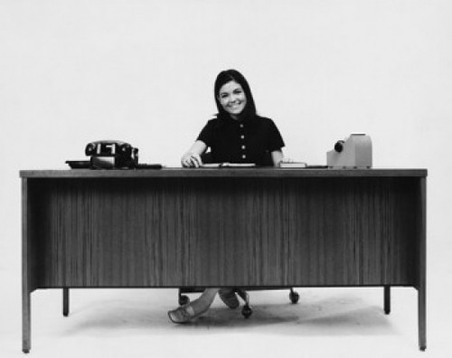 Businesswoman sitting at a desk and smiling in an office Poster Print - Item # VARSAL25528140