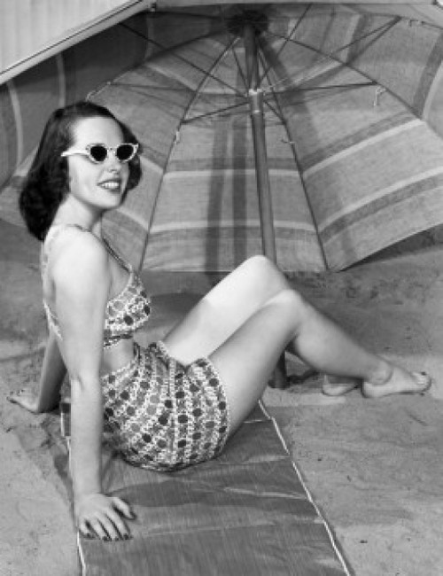 Young woman sitting under beach umbrella Poster Print - Item # VARSAL2557227
