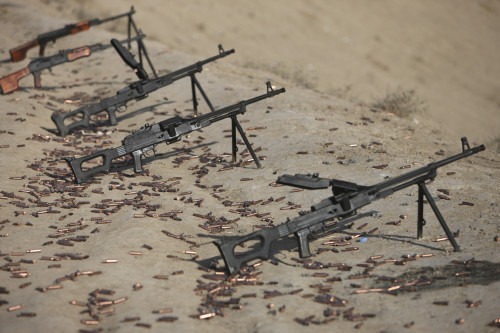 PK 7.62mm general-purpose machine guns and spent cartridges at the firing range in Kunduz, Afghanistan. A couple of RPK Kalashnikov hand-held machine guns are visible in the background Poster Print - Item # VARPSTTMO100440M
