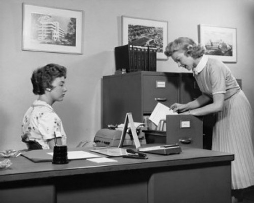 Side profile of two businesswomen working in office Poster Print