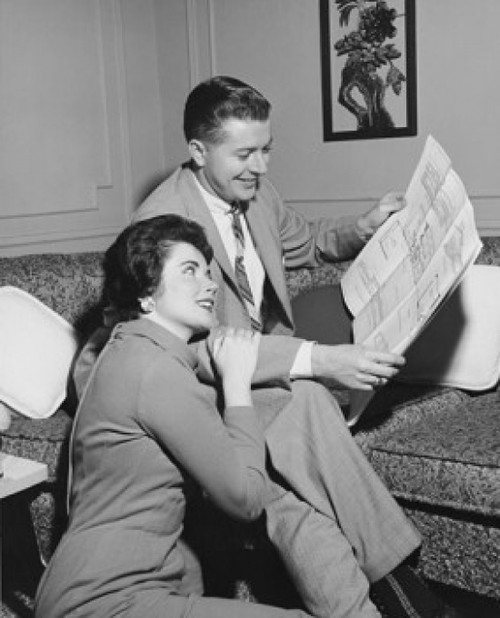 Mid adult couple looking at a blueprint and smiling Poster Print - Item # VARSAL25549089