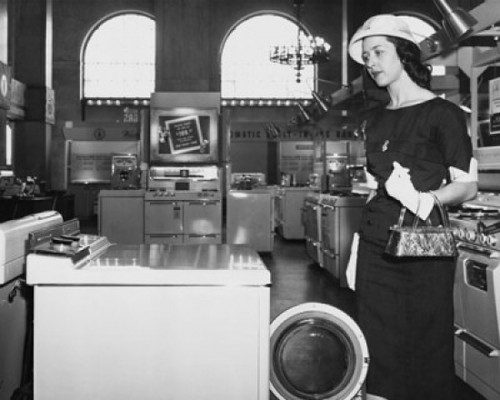 Close-up of a young woman looking at a washing machine Poster Print - Item # VARSAL255383