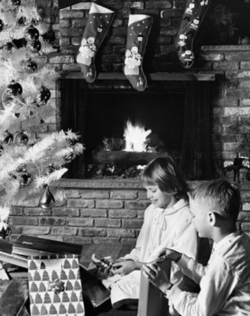 Side profile of a girl and her brother unwrapping Christmas presents near a fireplace Poster Print - Item # VARSAL25510457B
