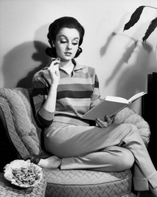 Young woman sitting on an armchair reading a book Poster Print - Item # VARSAL2555219