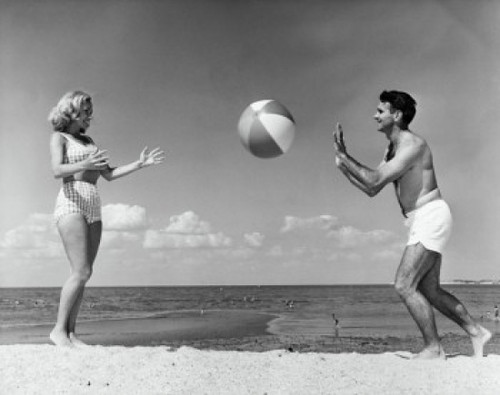 Young couple playing with beach ball on beach Poster Print - Item # VARSAL2556622