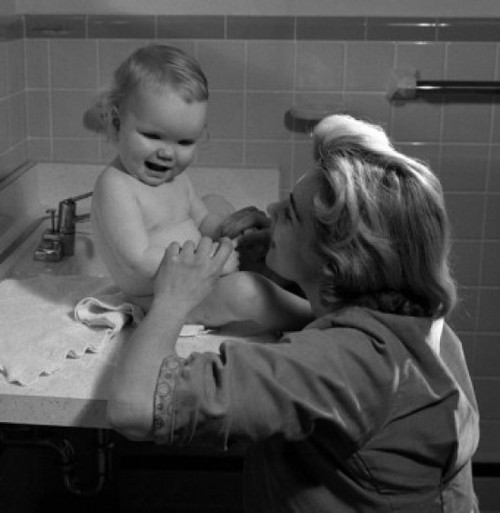 Young woman and baby girl sitting on bathroom sink Poster Print - Item # VARSAL2559886