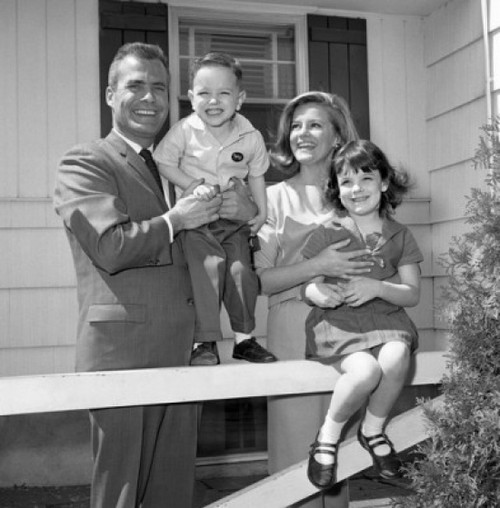 Mature couple with two children in front of the house Poster Print - Item # VARSAL255417406