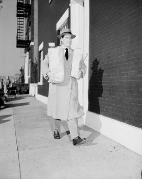 Young man walking on sidewalk carrying shopping bags Poster Print - Item # VARSAL255419249