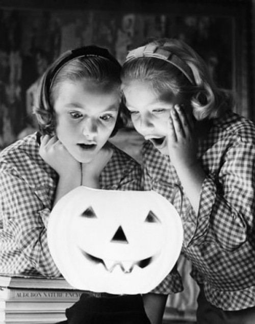 Close-up of two girls looking at an illuminated jack o' lantern Poster Print - Item # VARSAL25536167