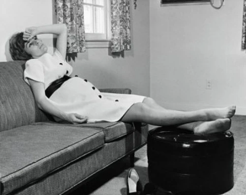 Pregnant woman sitting on a couch Poster Print