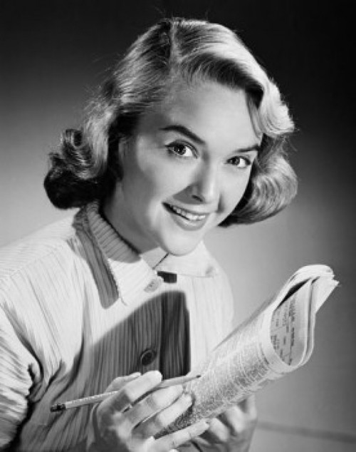 Portrait of a young woman smiling holding a newspaper Poster Print
