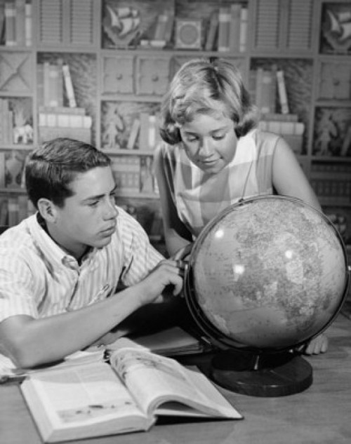 Teenage boy and his sister looking at a globe Poster Print