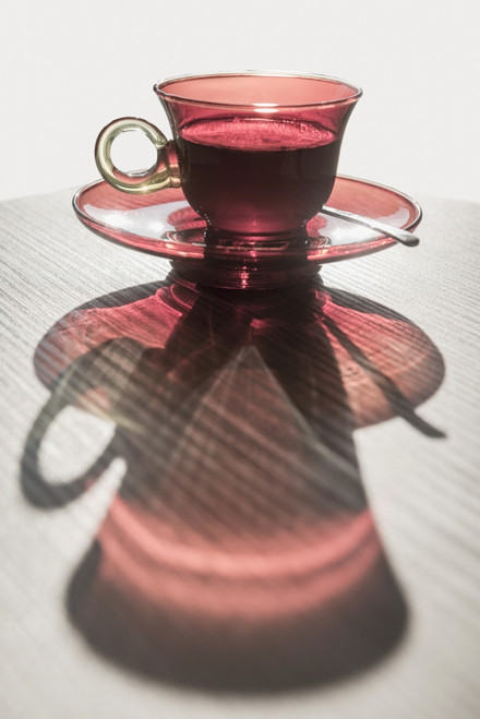 A red glass cup a saucer with a beverage reflected on a white surface; Locarno, Ticino, Switzerland PosterPrint - Item # VARDPI12281436