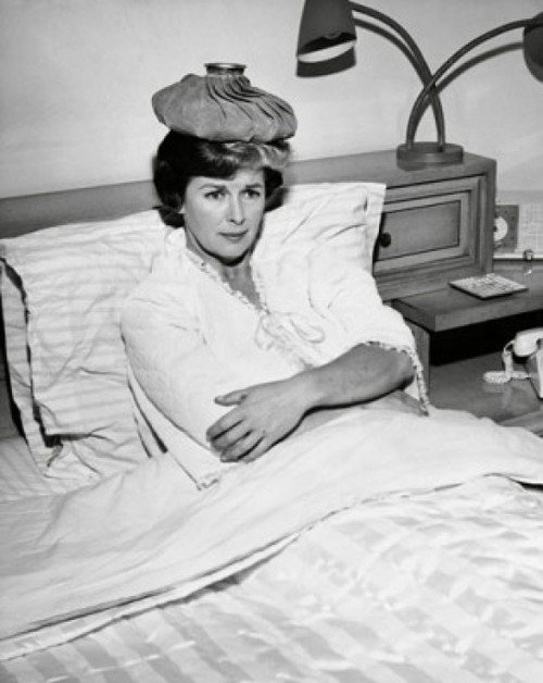 Mid adult woman reclining on the bed with an ice pack on her head Poster Print - Item # VARSAL25525603