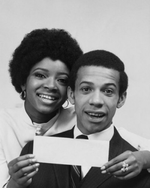 Portrait of a young woman smiling with a young man and holding a check Poster Print - Item # VARSAL2555324