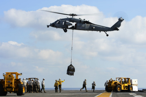 South China Sea, February 8, 2013 - An MH-60S Sea Hawk helicopter lowers pallets of supplies during a vertical replenishment on the flight deck aboard the amphibious assault ship USS Bonhomme Richard Poster Print - Item # VARPSTSTK106791M