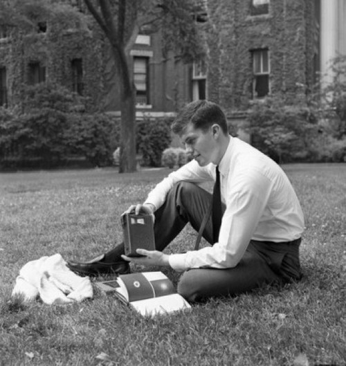 Portrait of male student reading book and listening to radio outside university building Poster Print - Item # VARSAL255420785