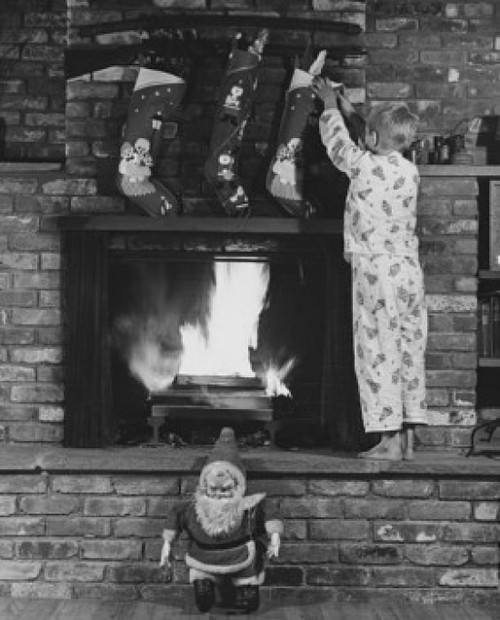 Rear view of boy standing on fireplace and grabbing Christmas stocking Poster Print - Item # VARSAL25525146