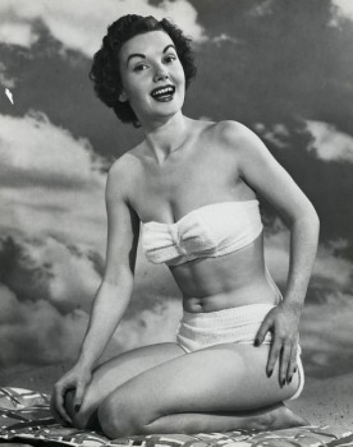 Portrait of a young woman kneeling on the beach and smiling Poster Print - Item # VARSAL2553954B