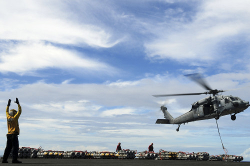 An MH-60S Sea Hawk lifts a pallet of ordnance from the aircraft carrier USS Ronald Reagan Poster Print - Item # VARPSTSTK104826M