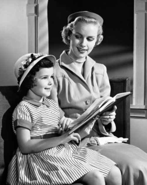 Mid adult woman sitting with her daughter and holding a Bible Poster Print - Item # VARSAL25543234B