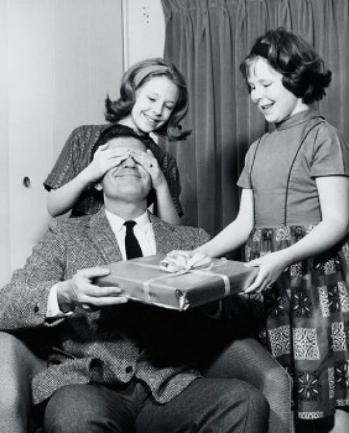 Close-up of two daughters giving a surprise gift to their father Poster Print - Item # VARSAL2557067