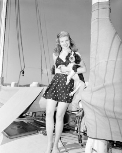 Young woman standing on boat and holding dog Poster Print - Item # VARSAL255424522