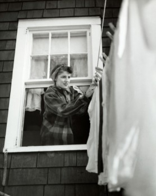 Low angle view of a young woman hanging clothes on a clothesline Poster Print - Item # VARSAL25518618