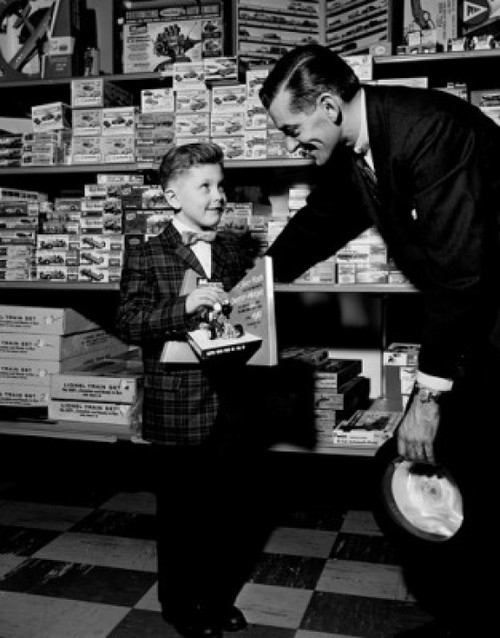 Shop assistant serving boy in toy shop Poster Print