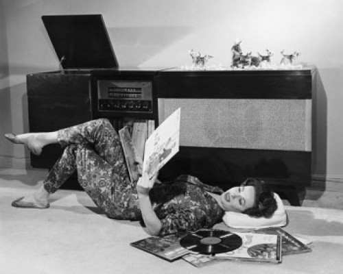 Side profile of a young woman lying on the floor holding records Poster Print - Item # VARSAL25541808