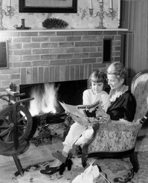 Senior woman reading story to her granddaughter near fireplace Poster Print - Item # VARSAL25518643B