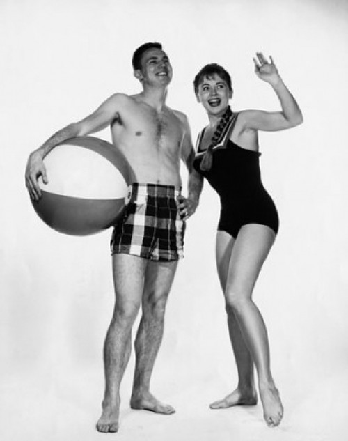 Young man holding a beach ball with a young woman waving Poster Print - Item # VARSAL2558874