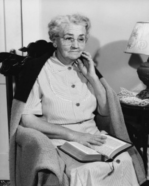 Senior woman sitting in a rocking chair with the Bible on her lap Poster Print - Item # VARSAL25549012
