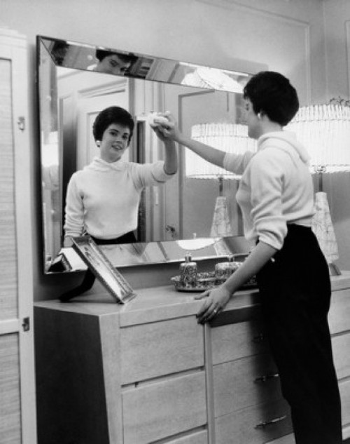 Side profile of a young woman cleaning the mirror of a dressing table Poster Print - Item # VARSAL25541892