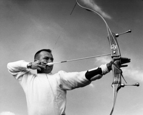 Mid adult man aiming with a bow and arrow Poster Print - Item # VARSAL25524645