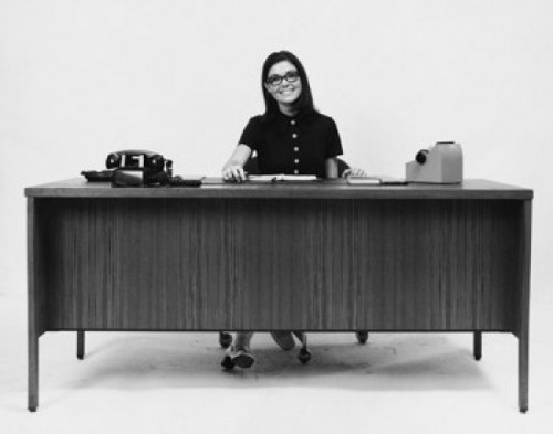 Businesswoman sitting at a desk and smiling in an office Poster Print - Item # VARSAL25548442