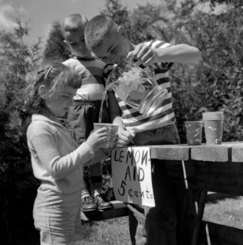 Boy pouring lemonade into disposable cup holding by girl Poster Print - Item # VARSAL25516279
