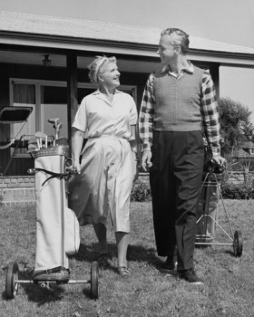 Senior couple walking with golf clubs on golf course Poster Print - Item # VARSAL25548892