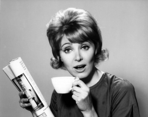 Portrait of a mid adult woman holding a tea cup and a newspaper Poster Print - Item # VARSAL25512630