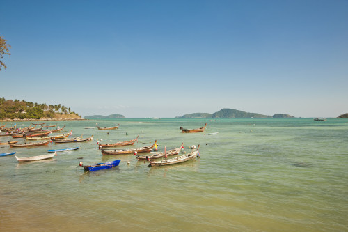 Thailand, Phuket, Rawaii Beach, Longtail boats along the shoreline, Land in distance. PosterPrint - Item # VARDPI2116492