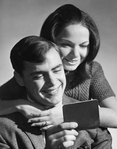 Close-up of a young couple reading a bankbook and smiling Poster Print - Item # VARSAL25520833