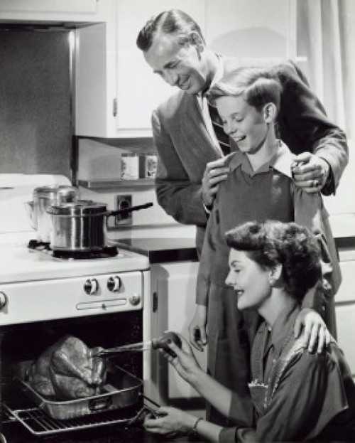 Parents and their son preparing a turkey in the kitchen Poster Print