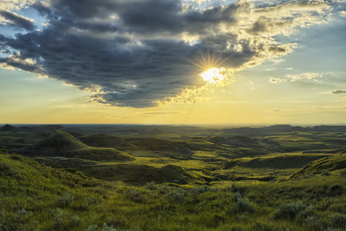 The sun shines through a cloud over the Killdeer Badlands, Grasslands National Park; Saskatchewan, Canada PosterPrint - Item # VARDPI12252437