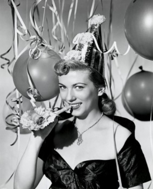 Portrait of a young woman holding a noisemake and smiling Poster Print - Item # VARSAL25510233A