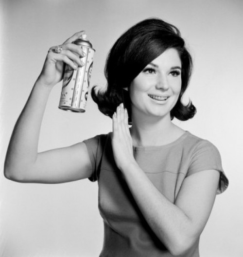 Young woman using hairspray Poster Print