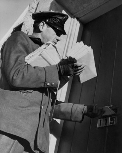 Postman dropping mail in mail slot  low angle view Poster Print - Item # VARSAL25528923